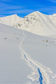 a trail in the snow leading to a mountain