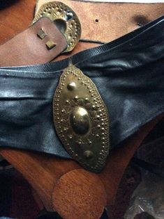 "Vintage artisan made corset belt very soft lamb skin attached to sturdy black leather. Large shield, brass on copper. Buckle is 6\" x 3\" .attached to v shaped lamb skin panel.brass,copper ovals at each end of v panel. Large piece for back closure. 3 adjustable holes. 24\" 25\" 27\" . In fantastic vintage condition. I've left it alone as everyone has their own style, great patina. Some shoe polish and mink oil would be my suggestion. Great eighties club belt" Medieval Style Corset Belt For Festivals, Medieval Corset Belt For Festivals, Leather Steampunk Corset Belt For Festivals, Steampunk Leather Corset Belt For Festivals, Leather Corset Belt For Festivals, Brass Belt, Vintage Throws, Vintage Throw Pillows, Vintage Corset