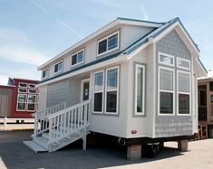 a tiny house on wheels with stairs leading up to it