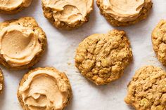 cookies with peanut butter frosting are arranged on a sheet of parchment paper, ready to be eaten