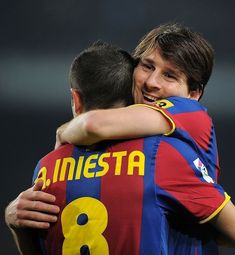 two soccer players hugging each other on the field