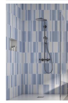 a bathroom with blue and white tiles on the wall, shower head and handset