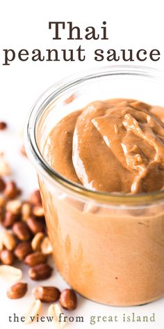 a jar filled with peanut sauce next to nuts