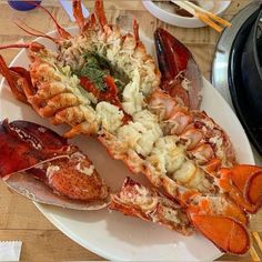 lobsters and other seafood on a plate with chopsticks