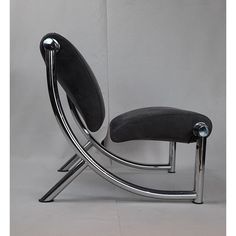 a black chair sitting on top of a metal frame next to a white wall and floor