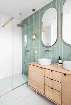 a bathroom with two sinks and mirrors on the wall