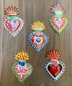 four heart shaped paper ornaments on a wooden surface