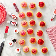 the cupcakes are decorated with red icing and pink fondant, along with other decorating supplies