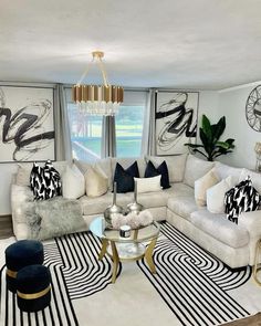 a living room filled with white couches and black and white rugs