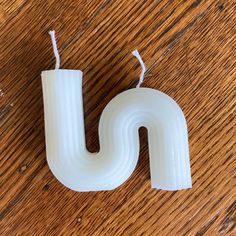 the letter u is made out of plastic and sits on a wooden table with string