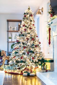 a white christmas tree with red and green ornaments