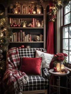 a living room decorated for christmas with plaid furniture and red decorations on the windowsill