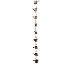 a tall metal pole with several pots hanging from it's sides and two lights on each side