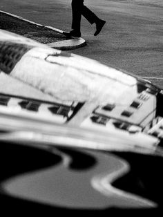 black and white photograph of a person walking down the street