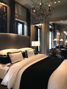 a bedroom with a large bed and chandelier