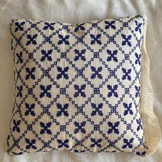 a blue and white pillow on top of a bed