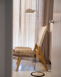 a floor lamp sitting on top of a wooden chair