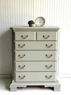 a white dresser with gold handles and knobs