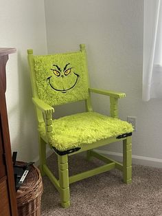 a green chair with a smiley face drawn on it's seat in a room