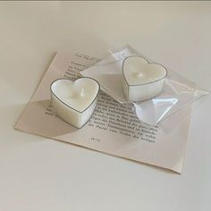 two heart shaped candles sitting on top of a piece of paper next to each other