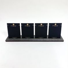 three black folders sitting on top of a wooden shelf next to eachother