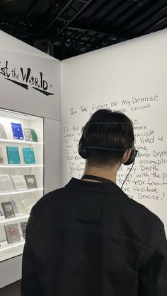 a man wearing headphones standing in front of a display case