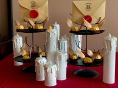 three tiered trays holding different types of candy and candies, each with an envelope on top