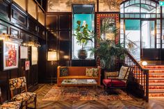 a living room filled with lots of furniture next to a stair leading up to a window