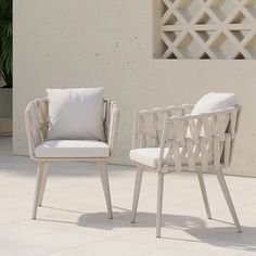 two chairs sitting next to each other on top of a white tile covered patio area