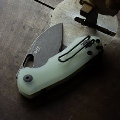 a green knife sitting on top of a wooden table