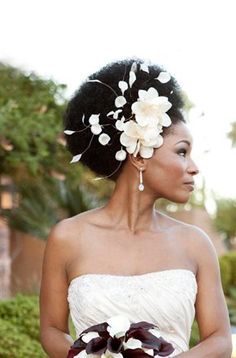 a woman in a wedding dress holding a bouquet with flowers on it's head