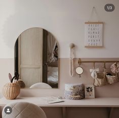 a white desk topped with a mirror next to a wall mounted clock and other items