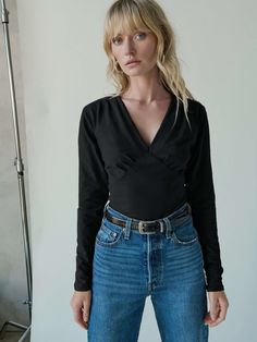 We heard you were looking for that simple, elegant staple that goes with everything. This top features pleats at the bodice and bust, waist panels, and a V-neckline. Simple, yet elegant. (This one comes in Jet Black.) | Andy Top in Jet Black | Ethical Essentials Chic Stretch V-neck Top For Work, Versatile Fitted Ruched Blouse, Chic Ruched Tops For Work, Chic Fitted V-neck Top For Night Out, Fitted Ruched Tops For Workwear, Chic V-neck Top With Gathered Waist, Modern V-neck Top For Night Out, Chic Solid Fitted V-neck Top, Chic Fitted Solid Color V-neck Top