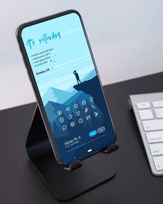 a cell phone sitting on top of a black desk next to a keyboard and mouse