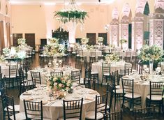 the tables are set with white linens and centerpieces for an elegant wedding reception