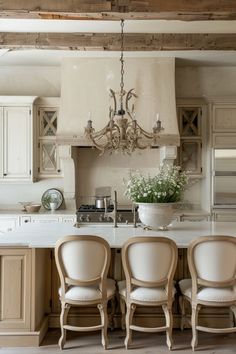 a kitchen with four chairs and a chandelier