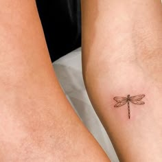 two legs with small tattoos on them and one has a dragonfly tattoo on it