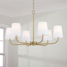 a chandelier with five lamps hanging from it's sides in a room