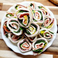 a white plate topped with sandwiches on top of a wooden cutting board next to a knife