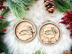 two wooden christmas ornaments sitting next to pine cones