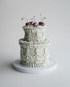 a three tiered cake with cherries on top