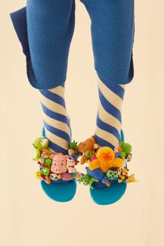 the legs and feet of a person wearing blue striped socks with animal decorations on them