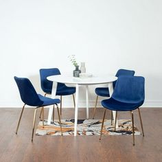 a white table with four blue chairs around it