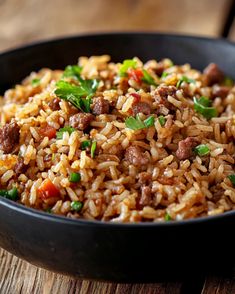 a bowl filled with rice and meat on top of a wooden table