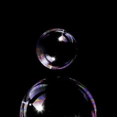 two bubbles floating in the air on a black background