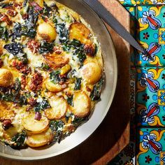 a pizza sitting on top of a pan covered in cheese and spinach toppings