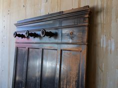 an old wooden cabinet with knobs on it