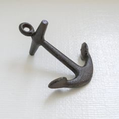 an iron anchor on a white surface