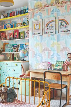 a child's room with colorful wallpaper and toys on the desk, bookshelves