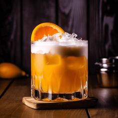 an orange drink with ice and garnish on a wooden table